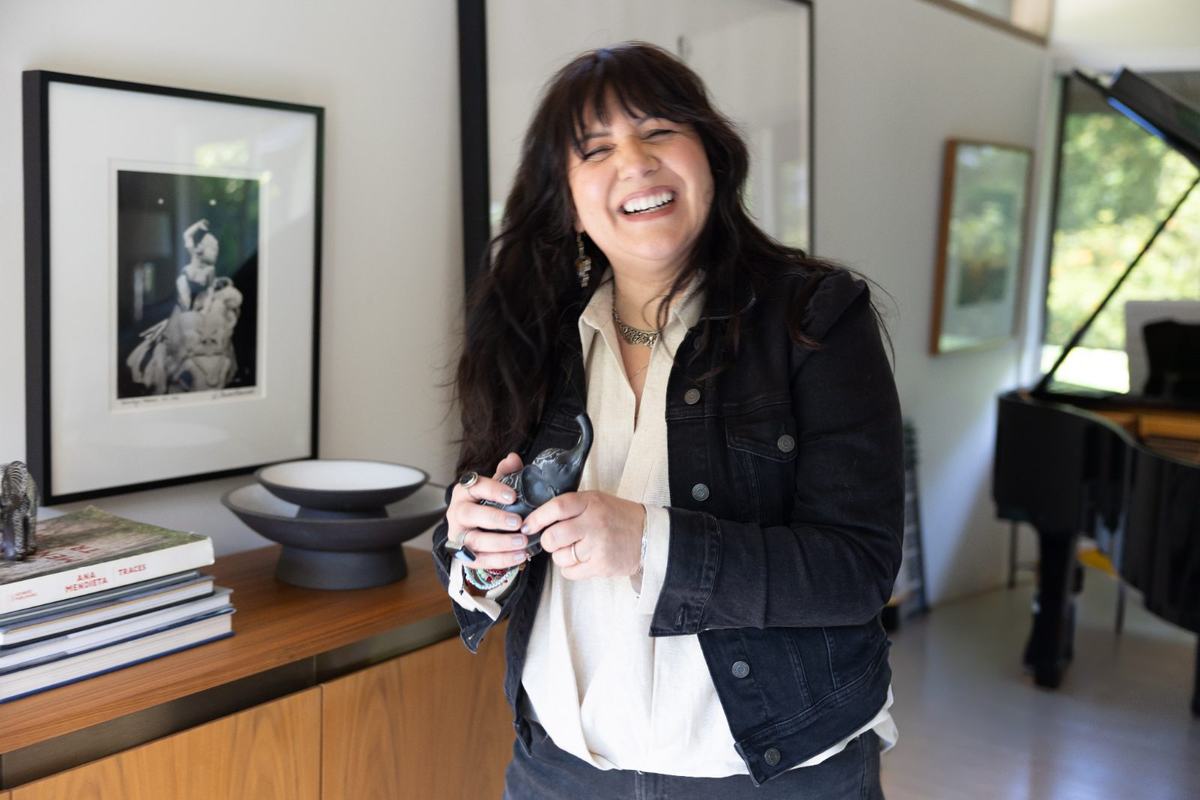 Frances Méndez laughing, holding a small carved elephant
