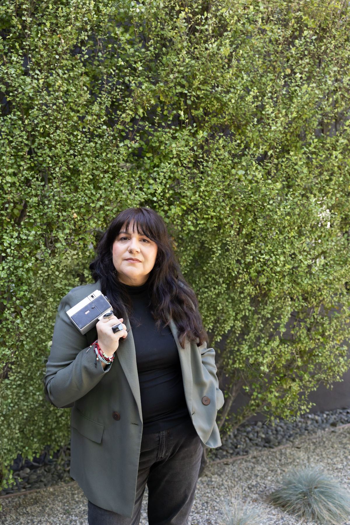 Frances Méndez outdoors, holding a vintage Super 8 camera